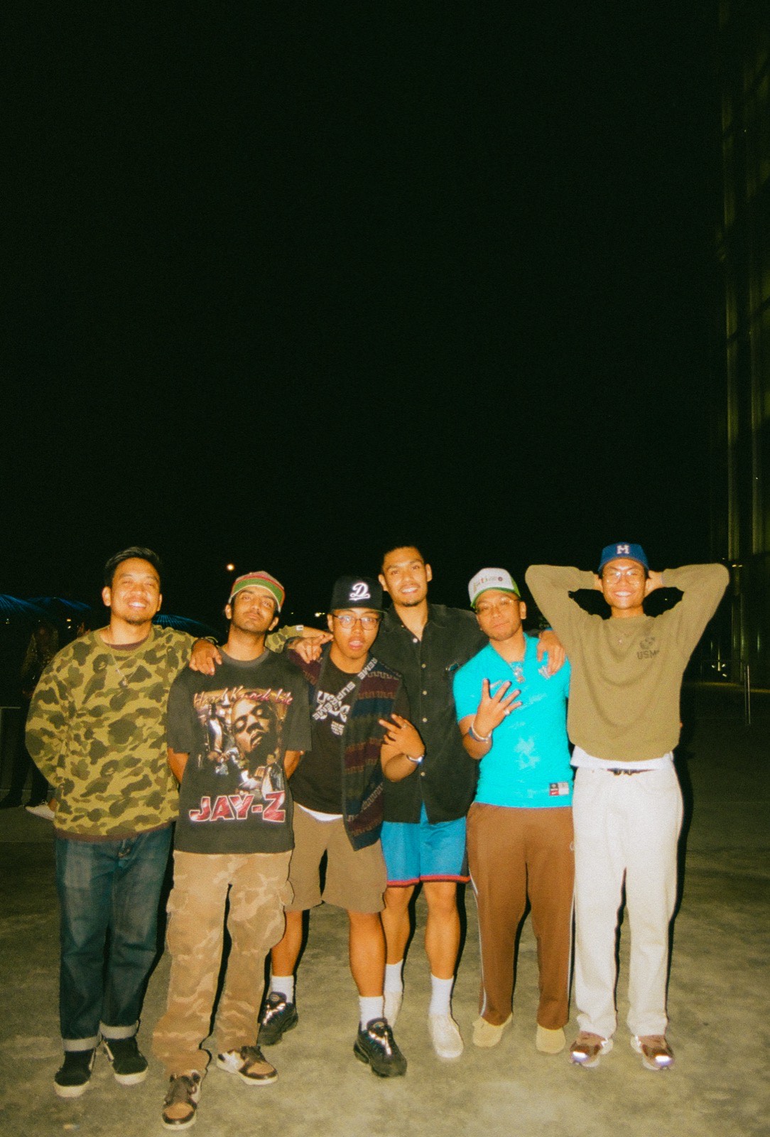 Six friends grouped for a portrait at night, lit by film flash